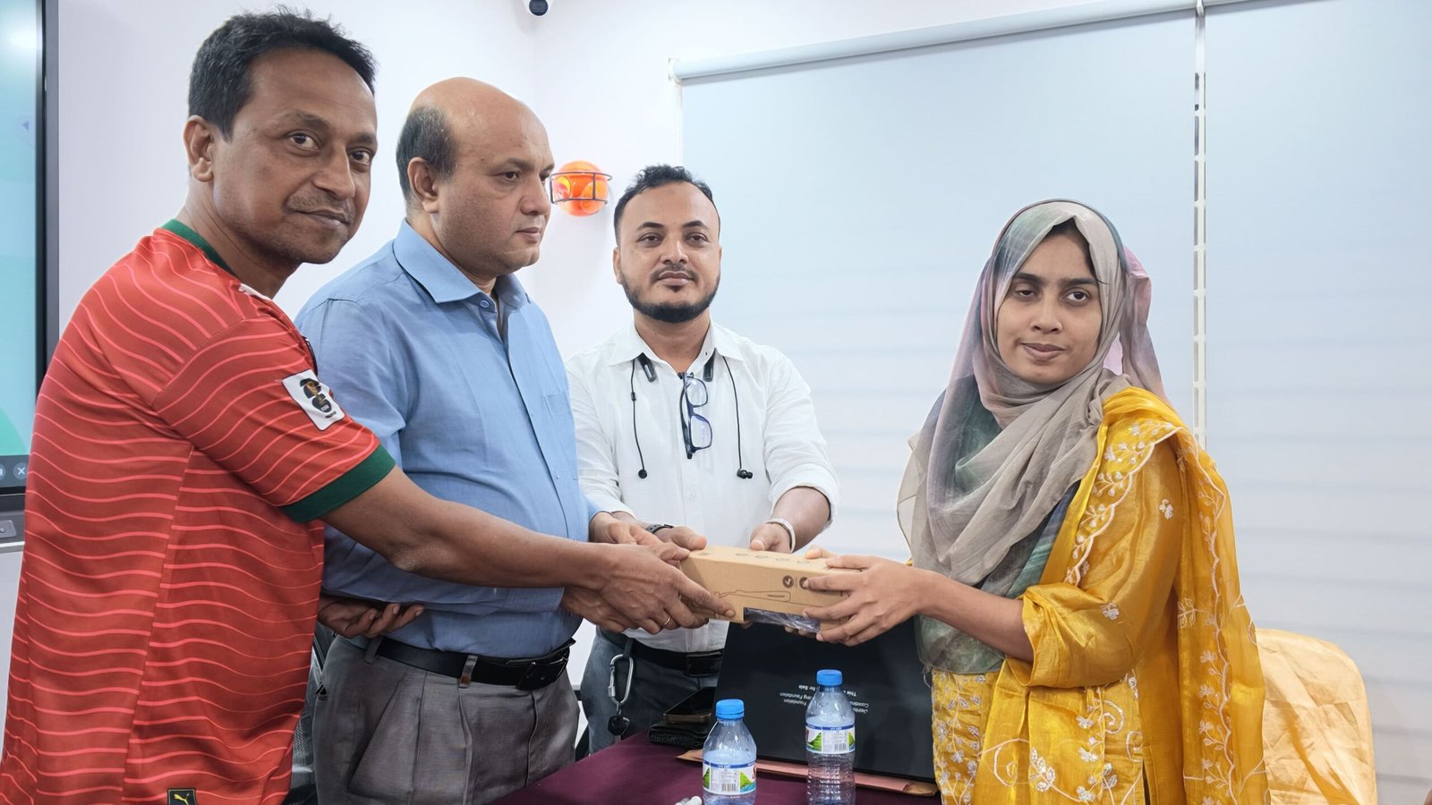 A female participant receiving an assistive device kit and certificate from project leaders during the Digital Rights & Resilience Bootcamp closing ceremony