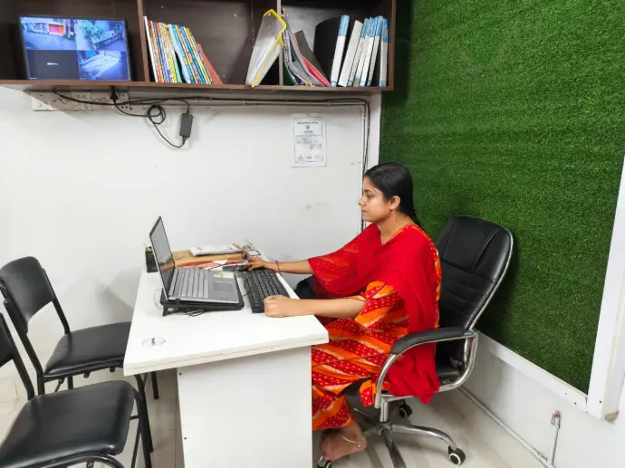 Loxme Roy reviewing digital graphics and design files on a computer monitor in an office setting.